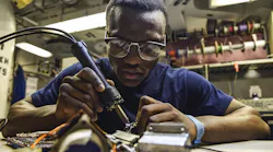 A Navy petty officer desolders a flex print assembly in the avionics shop of the aircraft carrier USS Dwight D. Eisenhower in the Persian Gulf.