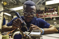 A Navy petty officer desolders a flex print assembly in the avionics shop of the aircraft carrier USS Dwight D. Eisenhower in the Persian Gulf. A Navy petty officer desolders a flex print assembly in the avionics shop of the aircraft carrier USS Dwight D. Eisenhower in the Persian Gulf.