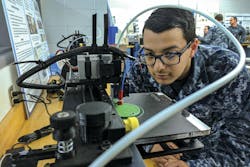 Navy Petty Officer 3rd Class Daniel Pastor examines a 3-D printer during a 3-D design and production course at Old Dominion University in Norfolk, Va., to service members how to design and print objects and parts that can help the fleet. Navy Petty Officer 3rd Class Daniel Pastor examines a 3-D printer during a 3-D design and production course at Old Dominion University in Norfolk, Va., to service members how to design and print objects and parts that can help the fleet.