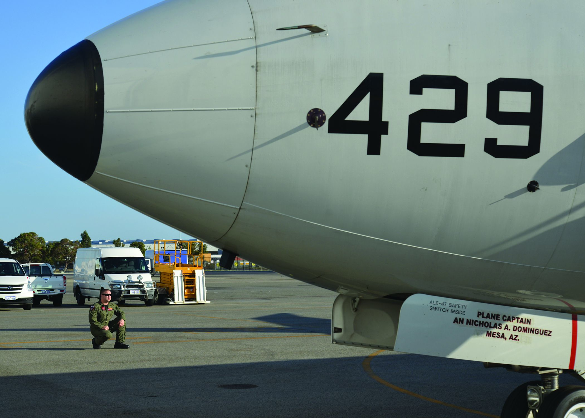 A U.S. Navy electronic warfare operator watches the exterior of a P-8A Poseidon maritime patrol aircraft during a high-frequency radio check before a mission.
