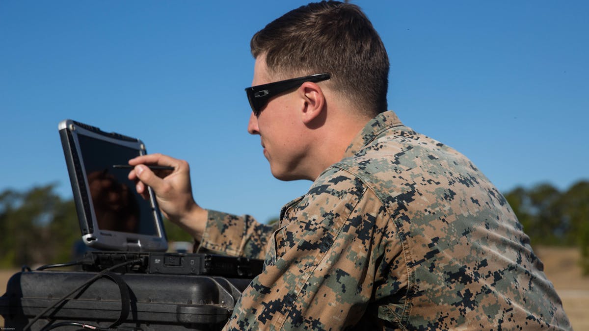 Sgt. Kyle Phillips configures computer equipment to ensure communications and controls connected to a Raven small unmanned aircraft system are working properly at Marine Corps Base Camp Lejeune, N.C.