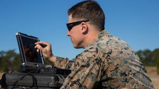 Sgt. Kyle Phillips configures computer equipment to ensure communications and controls connected to a Raven small unmanned aircraft system are working properly at Marine Corps Base Camp Lejeune, N.C.