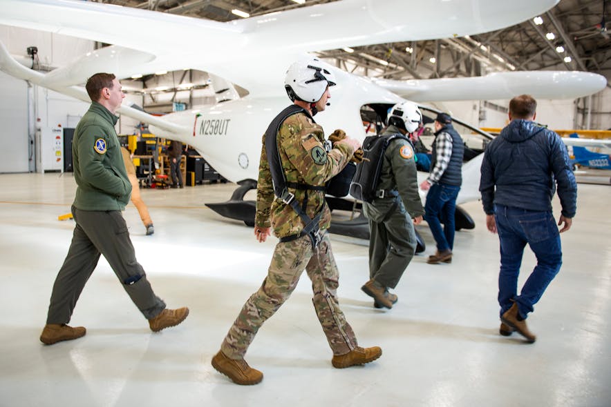 U.S. Air Force and BETA technologies team members walk toward an ALIA aircraft for a test flight.