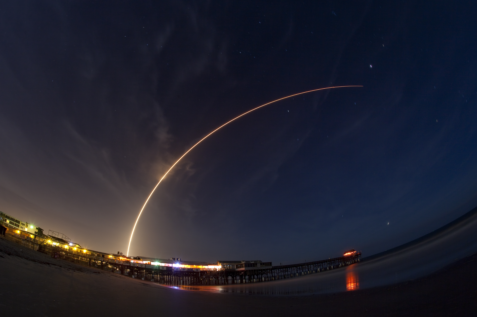 Cut: A two minute time exposure of the Altas V launch from Cape Canaveral Air Force Station, Florida. The 19-story United Launch Alliance Atlas V rocket carrying twin NASA satellites lifts off from Launch Complex 41. The photo was taken on the beach at Cocoa Beach with the fishing pier in the foreground. Photo 26393521 &copy; Mikephotos | Dreamstime.com