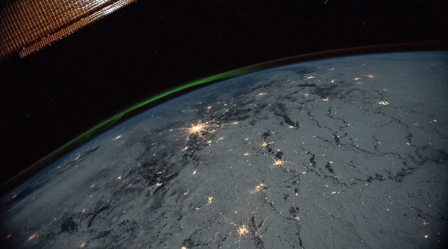 A portion of the International Space Station&apos;s solar arrays caps this nighttime view of Earth with aurora as the orbital complex orbited 258 miles above Ukraine and Russia. NASA image.