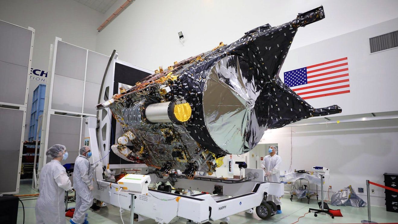 NASA&rsquo;s Psyche spacecraft is shown in a clean room at the Astrotech Space Operations facility near the agency&rsquo;s Kennedy Space Center in Florida on Dec. 8, 2022. DSOC&rsquo;s gold-capped flight laser transceiver can be seen, near center, attached to the spacecraft. Credit: NASA/Ben Smegelsky.