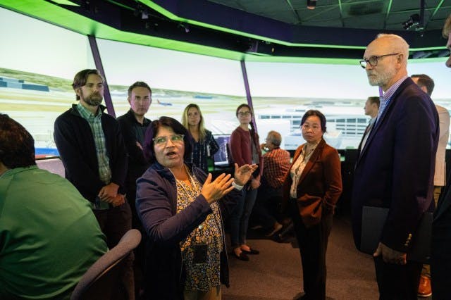 Savvy Verma, left, and Huy Tran, director of aeronautics at NASA&rsquo;s Ames Research Center in California&rsquo;s Silicon Valley, center, explain a recent air traffic management simulation to guests at Ames&rsquo; FutureFlight Central simulator. Credit: NASA/Jesse Carpenter