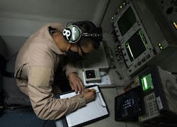 A U.S. Air Force senior airman writes down radar data while flying in an E-3 over Southwest Asia while flying a mission aboard the E-3 Sentry radar reconnaissance aircraft.