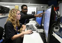A U.S. military network cryptologic technician helps a high school student complete cyber security challenges. Navy photo A U.S. military network cryptologic technician helps a high school student complete cyber security challenges. Navy photo