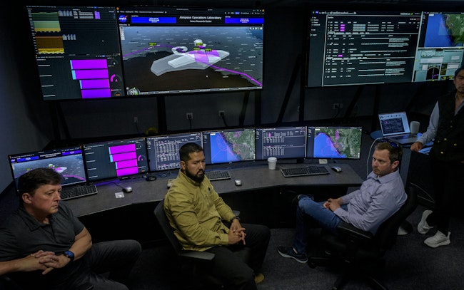 NASA and partners from Aerostar and AeroVironment discuss a simulation of a high-altitude air traffic management system for vehicles flying 60,000 feet and above in the Airspace Operations Lab (AOL) at NASA’s Ames Research Center in California’s Silicon Valley. NASA/Don Richey photo.