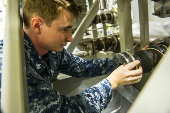 A Navy fire controlman installs a pump in the Dual Band Radar cooling system during routine maintenance aboard the aircraft carrier Gerald R. Ford (CVN 78).