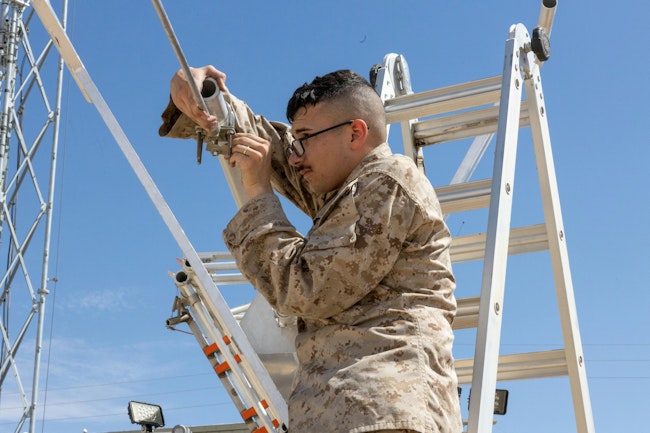 A U.S. Marine Corps transmission systems operator installs a 5G antenna for a demonstrat at the Marine Corps Air Ground Combat Center at Twentynine Palms, Calif. U.S. Marine Corps photo by Pfc. Ryan Kennelly