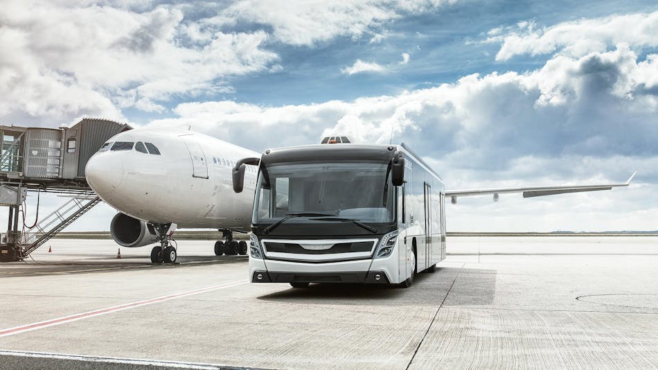 A front three-quarter shot of an electric bus alongside a commercial jet.