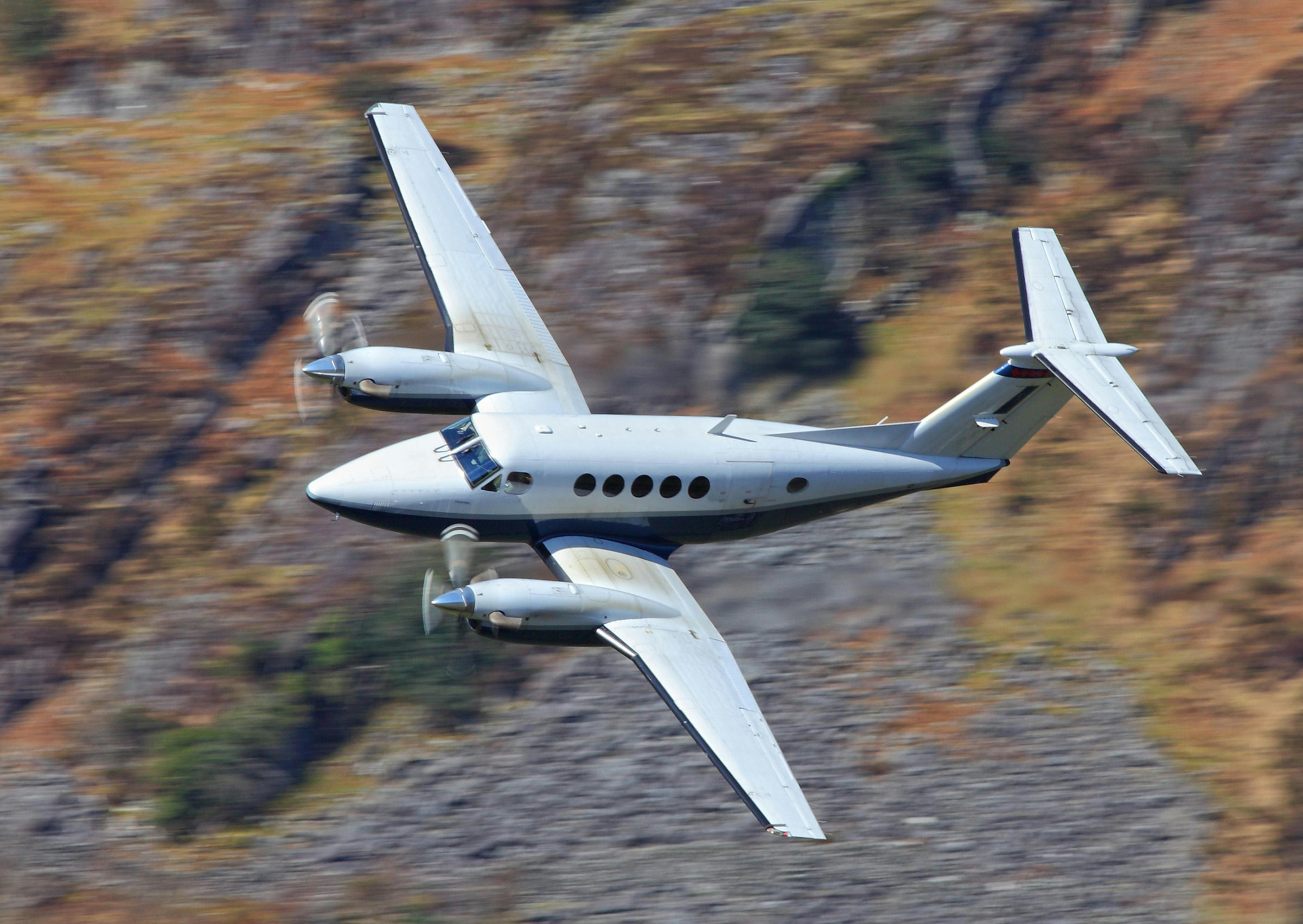 A King Air twin prop plane banks while in flight.