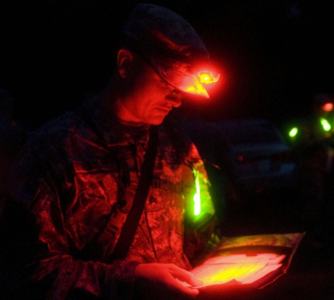 A military policeman reviews his coordinates to enter into the Defense Advanced Global Positioning System Receiver he will use for a night Land Navigation event.