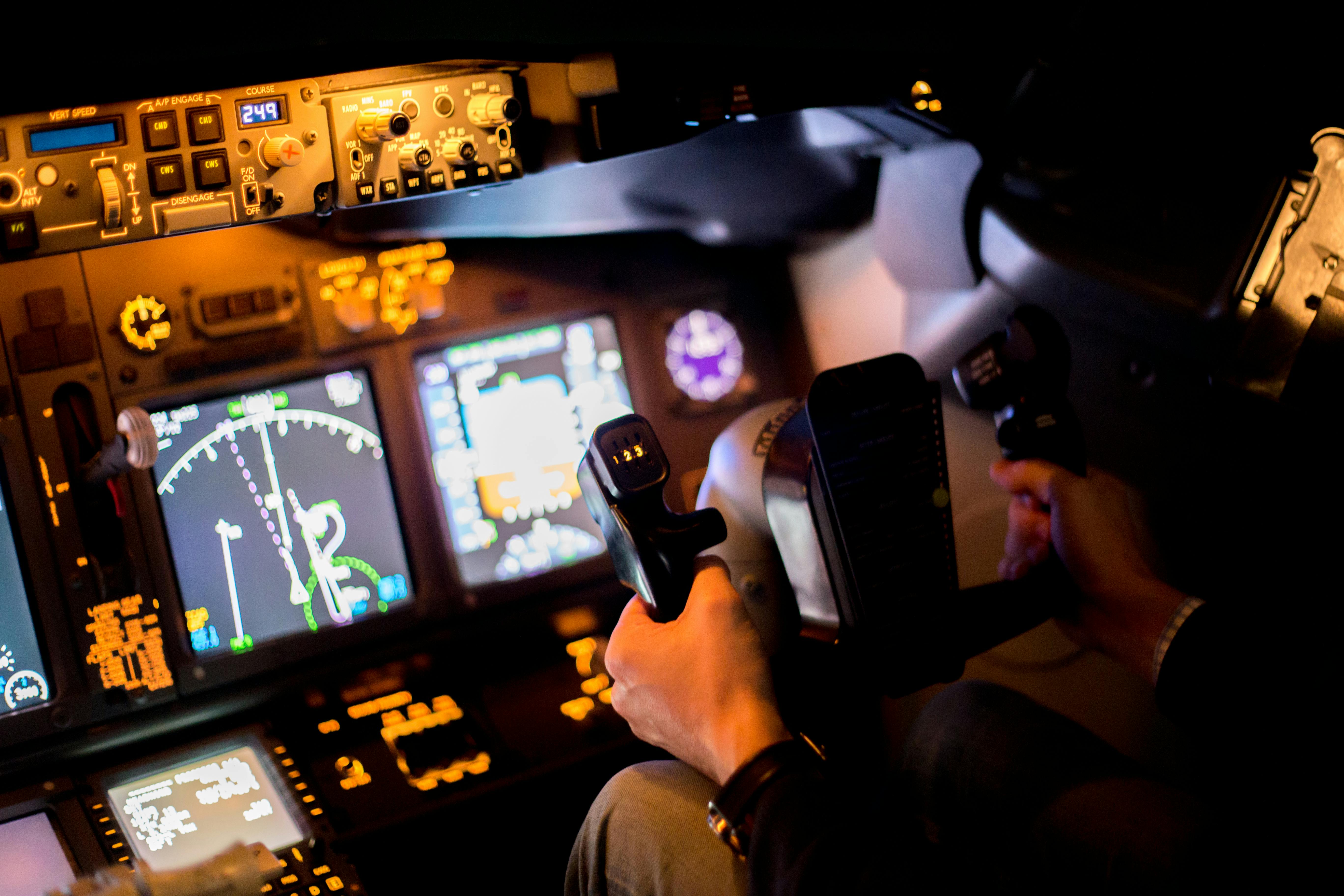 A pilot seated at a realistic aircraft training terminal.