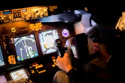 A pilot seated at a realistic aircraft training terminal. A pilot seated at a realistic aircraft training terminal.