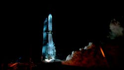 A side profile photo of a Blue Origin rocket firing on the ground at night. A side profile photo of a Blue Origin rocket firing on the ground at night.