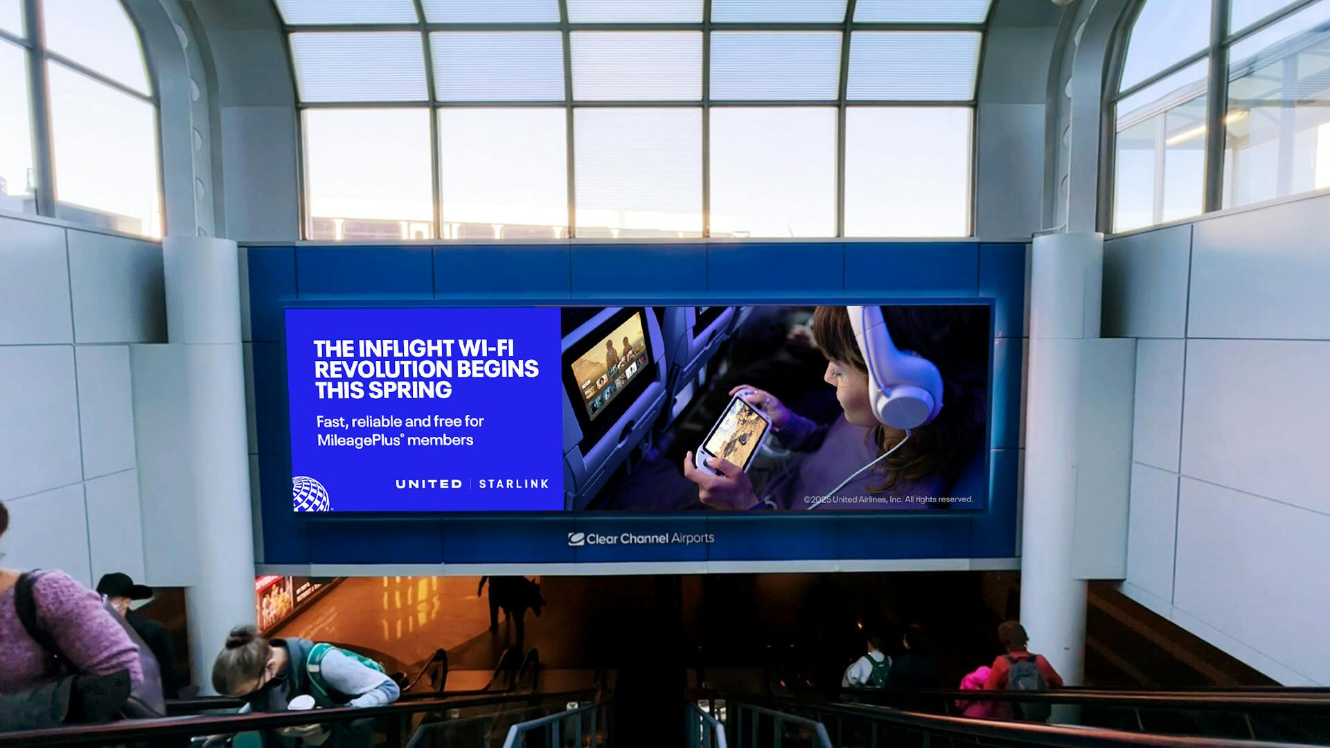 A United Airlines ad in an airport on a screen reading 'the inflight wi-fi revolution begins this spring.'