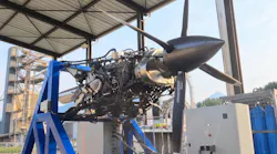 A photo of an unshrouded propeller aircraft engine on a stand.