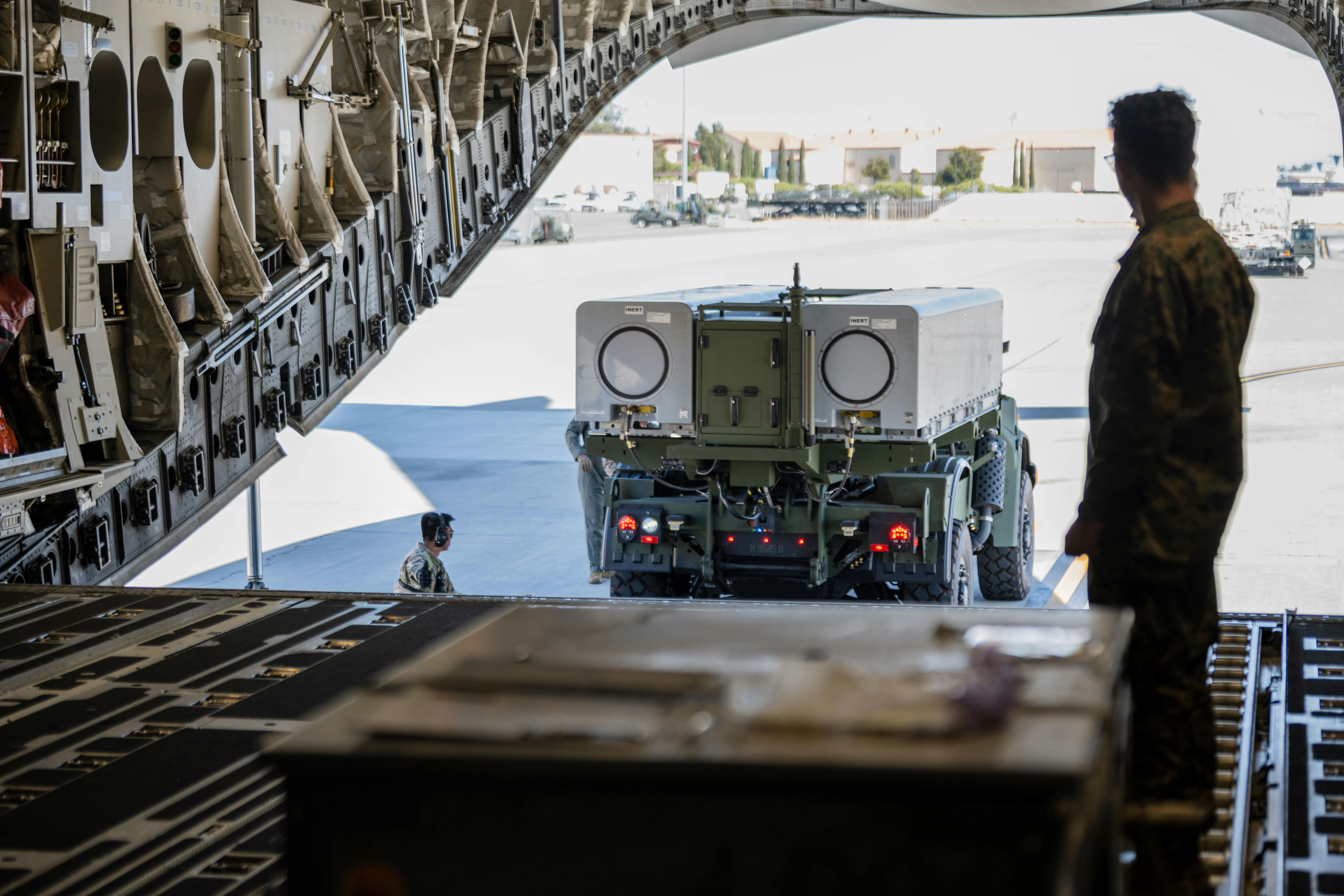 U.S. Marines back a Navy/Marine Corps Expeditionary Ship Interdiction System (NMESIS) launcher onto a C-17 cargo jet for transport at Travis Air Force Base, Calif.