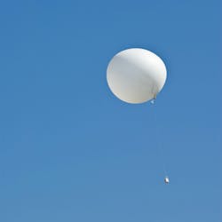 A weather balloon ascends amid a blue sky. A weather balloon ascends amid a blue sky.