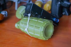 Small models of grenade defensive weapon printed on 3D printer from molten plastic on table. Small models of grenade defensive weapon printed on 3D printer from molten plastic on table.