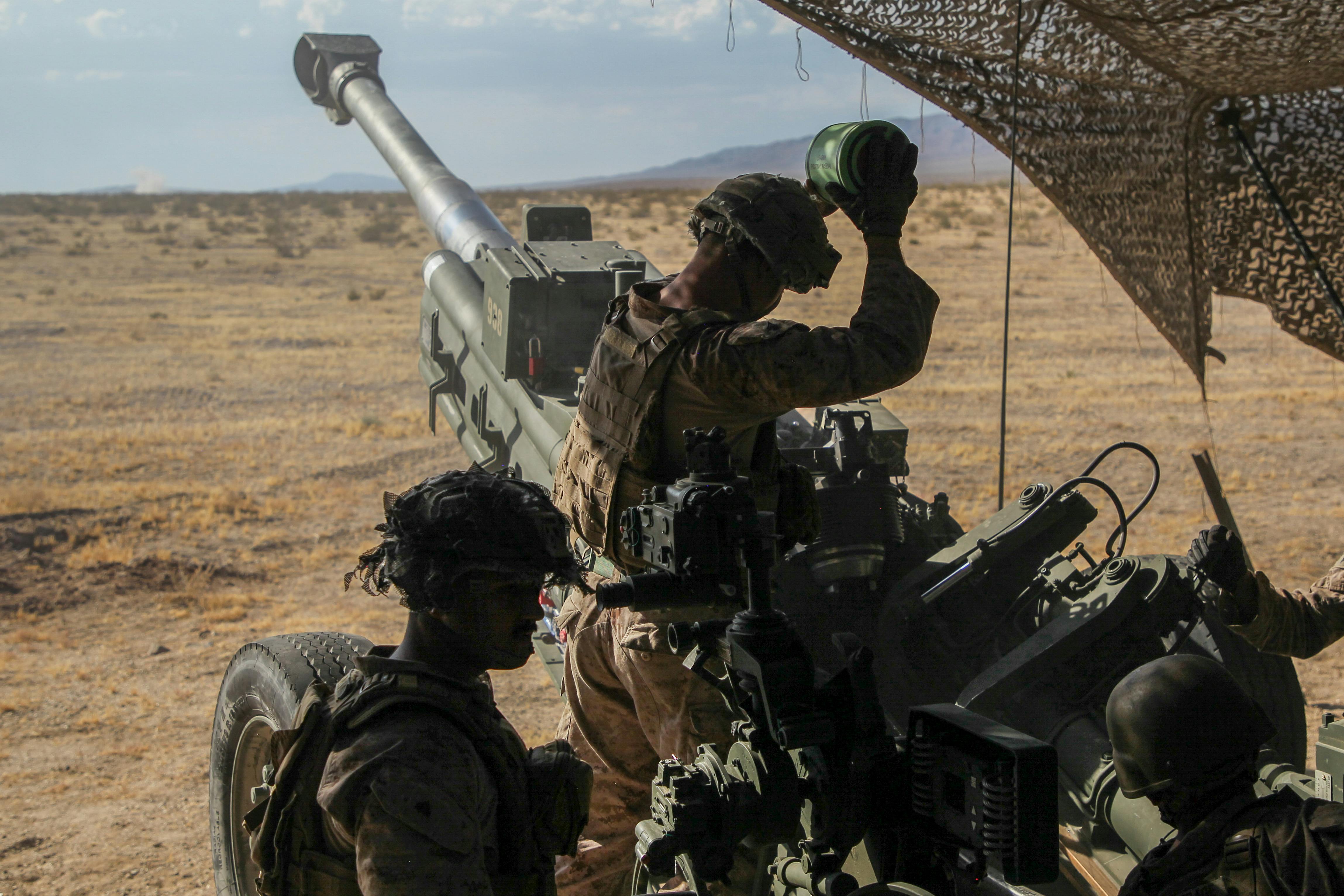 U.S. Marine Corps artillery cannoneer prepares to load an M777 towed 155-millimeter howitzer during an exercise at the Marine Corps Air-Ground Combat Center in Twentynine Palms, Calif.
