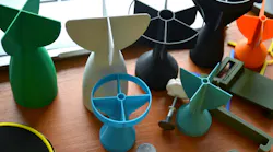 Prototype model of rocket bomb tip, colored models of tail fins, and tail cone printed on a 3D printer from molten plastic.