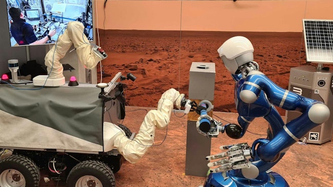 DLR's autonomous humanoid robot Rollin' Justin (right) and the ESA Interact Rover (left) being controlled from the International Space Station ISS. They are cooperating on the handling of a tool. Credit: DLR (CC BY-NC-ND 3.0).