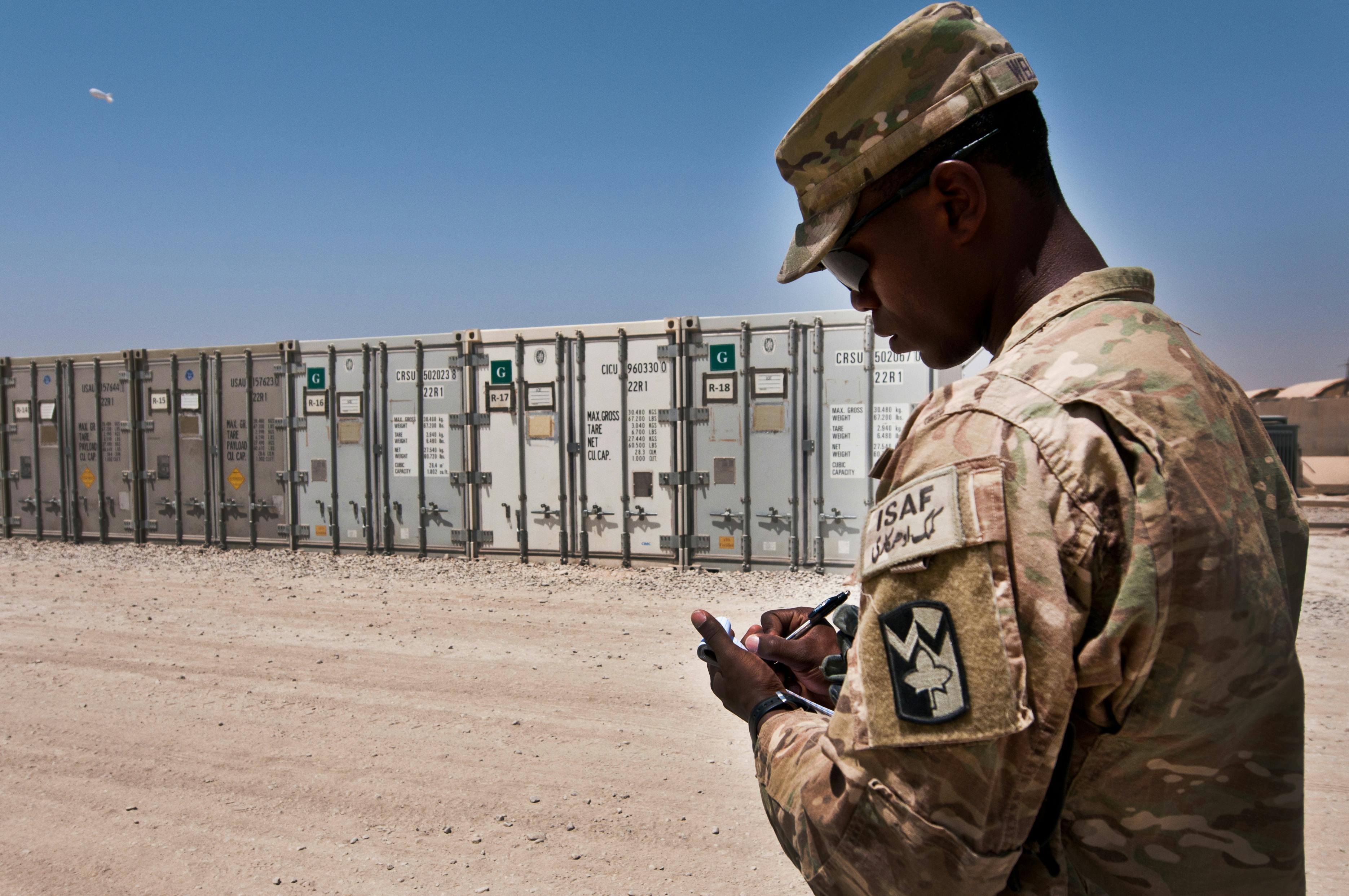 An Army soldier checks inventories refrigerated storage units, and supervises supply trucks.