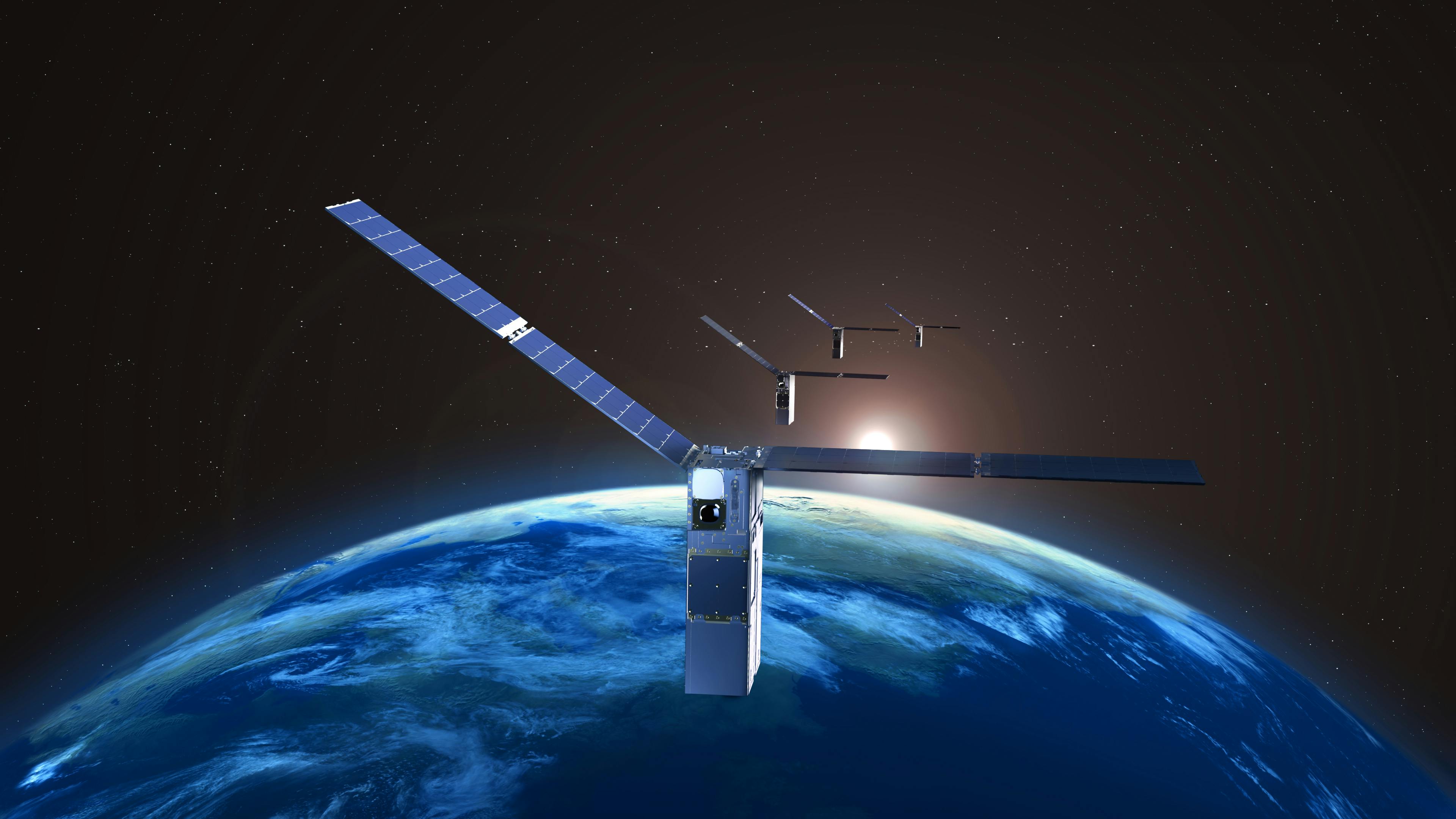 An image of three identical satellites above earth