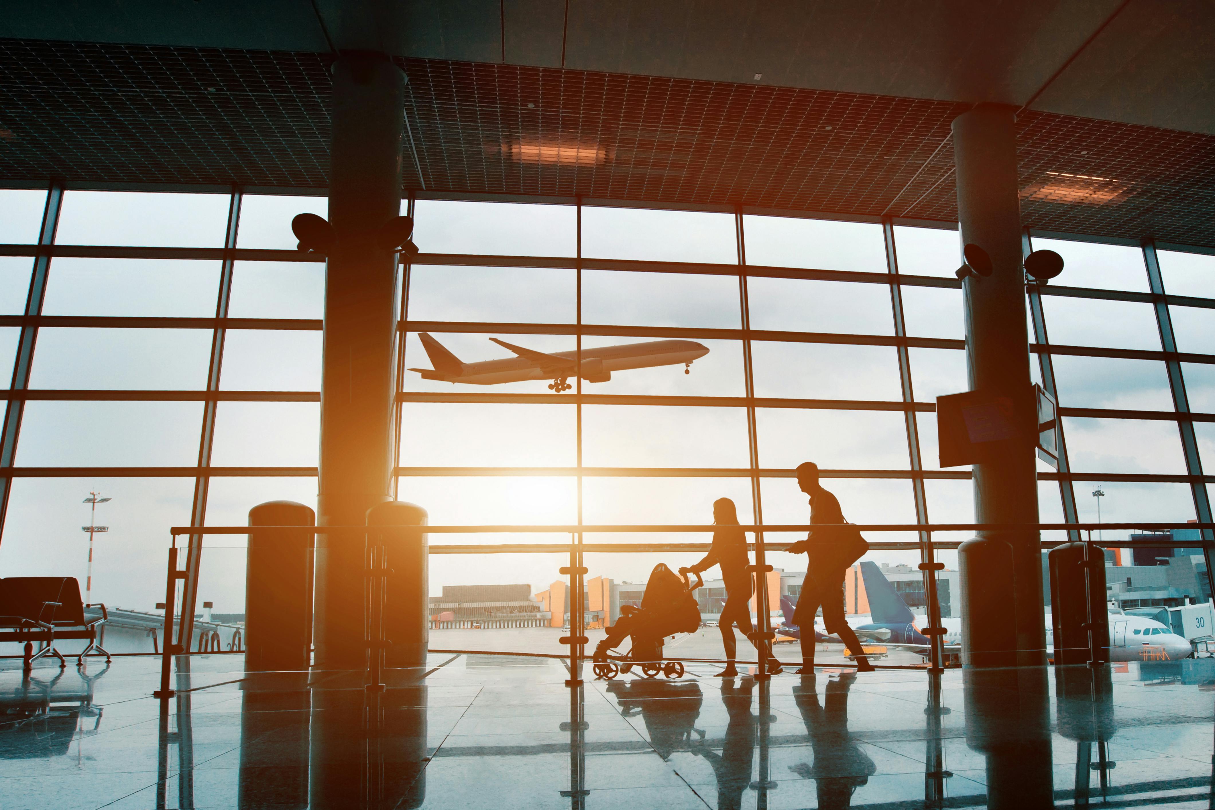 Family traveling with children, silhouette in airport.