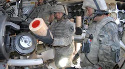 Army National Guardsmen load charges into the tube of an M-109A6 Paladin 155-millimeter self-propelled howitzer at National Training Center, Fort Irwin, Calif.