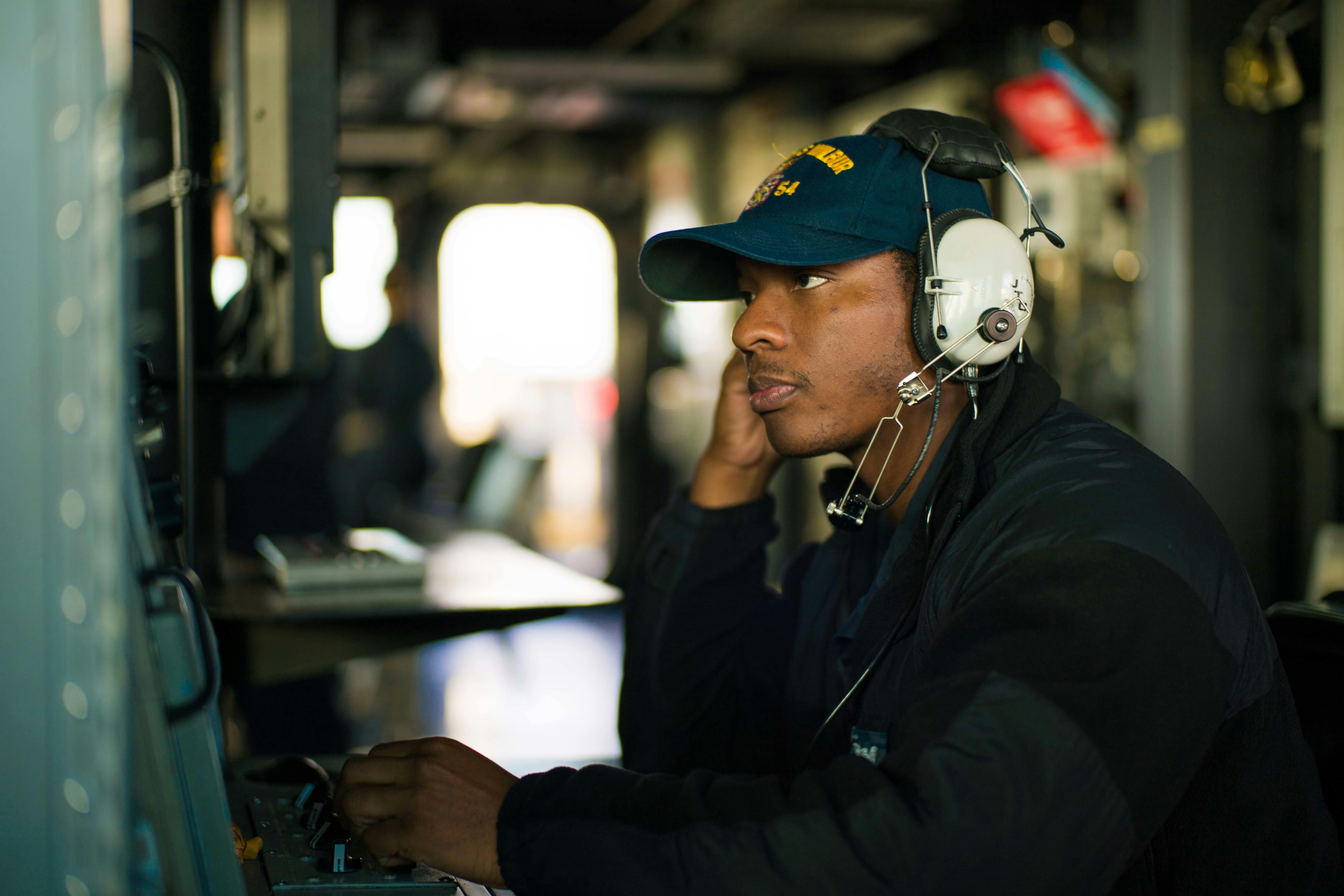An operations specialist aboard the Navy Burke-class destroyer USS Curtis Wilbur (DDG 54) monitors a radar console in the ship's pilot house.