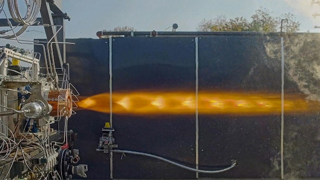 An imagine in profile of a rocket engine emitting a large flame horizontally