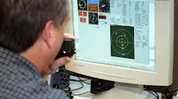 An unmanned vehicle ground controller examines the screen of his ground control station during tests in New Mexico.
