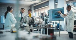 Four researchers in lab coats work on an aircraft engine Four researchers in lab coats work on an aircraft engine