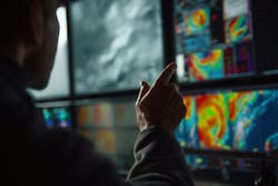 A meteorologist examines colorful weather radar maps on high-resolution monitors. A meteorologist examines colorful weather radar maps on high-resolution monitors.