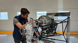 A technician looks at the hybrid engine as it sits on a stand