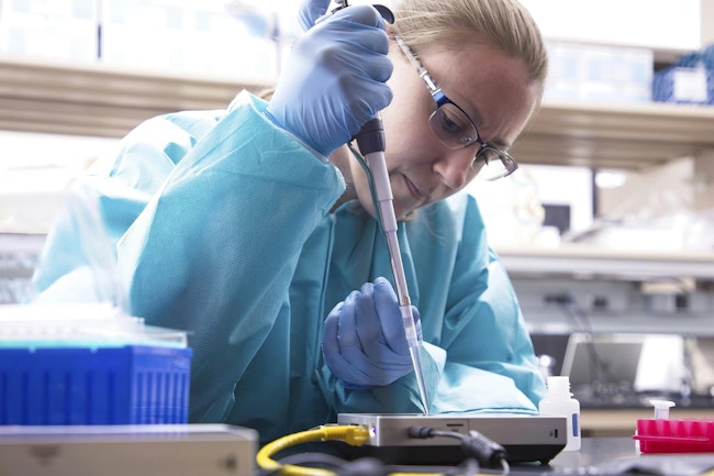 A researcher at the U.S. Navy Biological Defense Research Directorate prepares an instrument prior to sample loading and DNA sequencing.