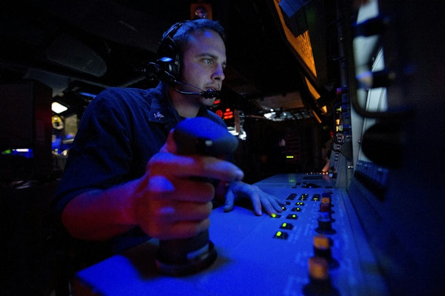 A Navy fire controlman stands watch in the combat information center aboard the guided-missile destroyer USS Arleigh Burke (DDG 51).