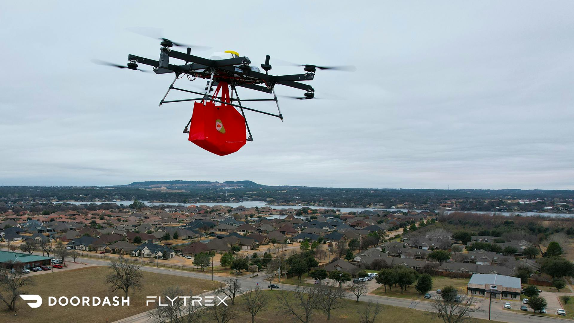 A Flytrex quad copter carrying a bag over a neighborhood