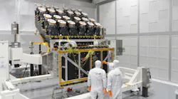 Three people in white clean suits in a clean room with the camera array