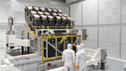 Three people in white clean suits in a clean room with the camera array Three people in white clean suits in a clean room with the camera array