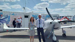 A photo of a man and a woman standing next to an uncrewed aircraft on the tarmac. A photo of a man and a woman standing next to an uncrewed aircraft on the tarmac.