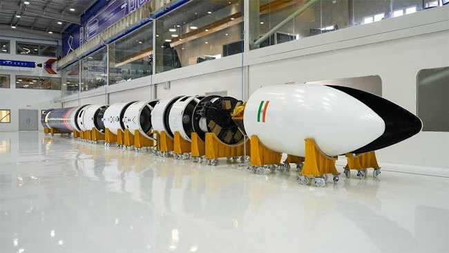 A photo of Skyroot's rocket in stages on the floor of a large white room.
