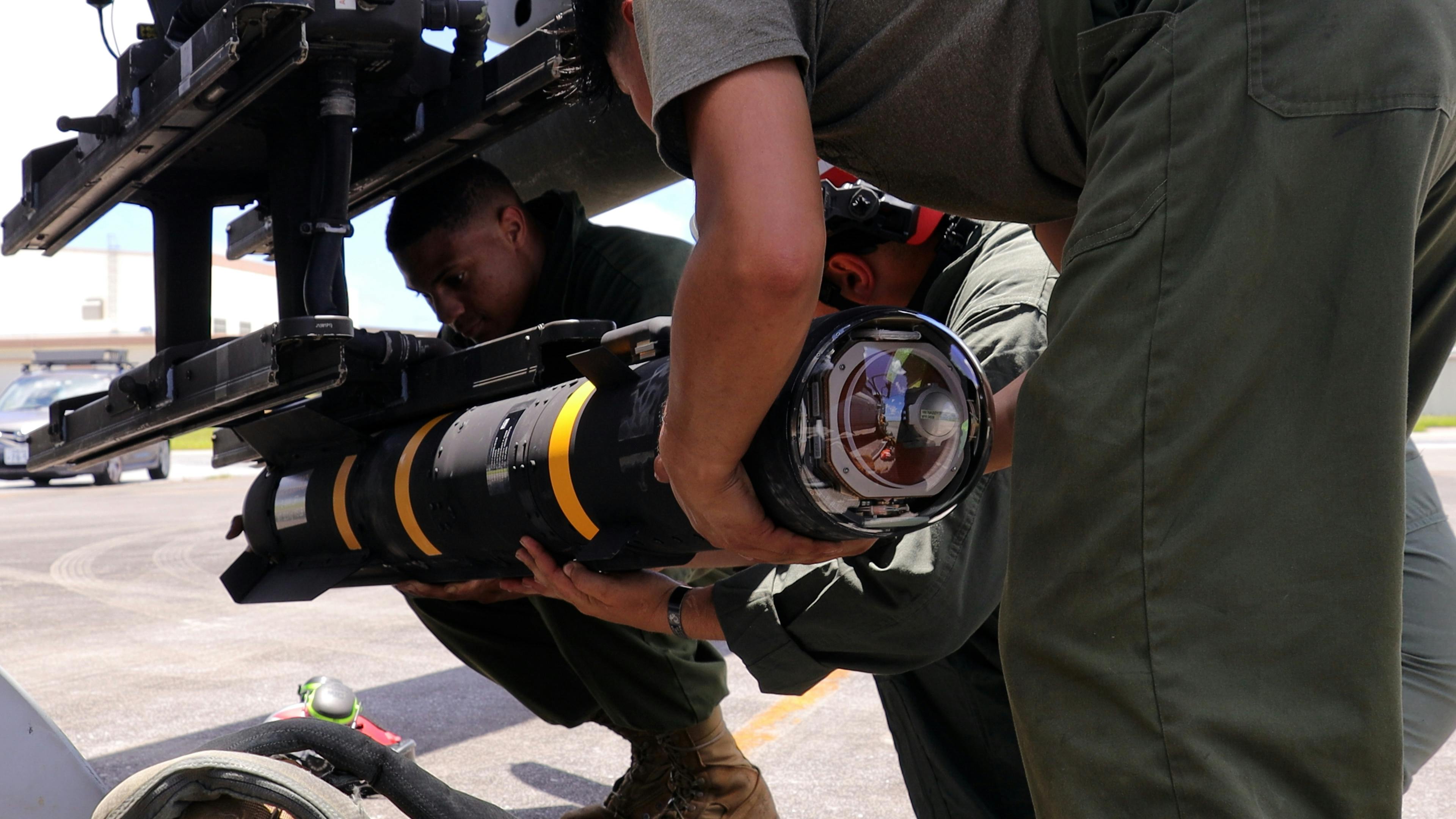 U.S. Marine Corps aviation ordnance technicians load an AGM-179 joint air-to-ground munition (JAGM) onto an AH-1Z M299 launcher at Kadena Air Base, Japan, in June 2024.