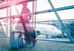 A stylized image of a passenger walking with a bag by an airport window. A stylized image of a passenger walking with a bag by an airport window.