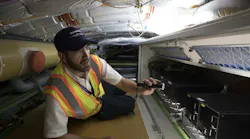 A Panasonic technician works in an airplane.